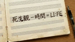 五線譜が印刷されたノートに「死生観 − 時間 ＝ LI:FE」と手書きされた文字の写真